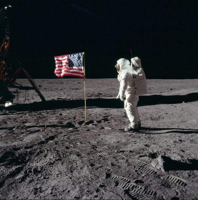 Астронавт Эдвин (Базз) Олдрин, член экспедиции на корабле Apollo 11, салютует первому американскому флагу, установленному на Луне; снимок сделан Нейлом Армстронгом 21 июля 1969 года. NASA