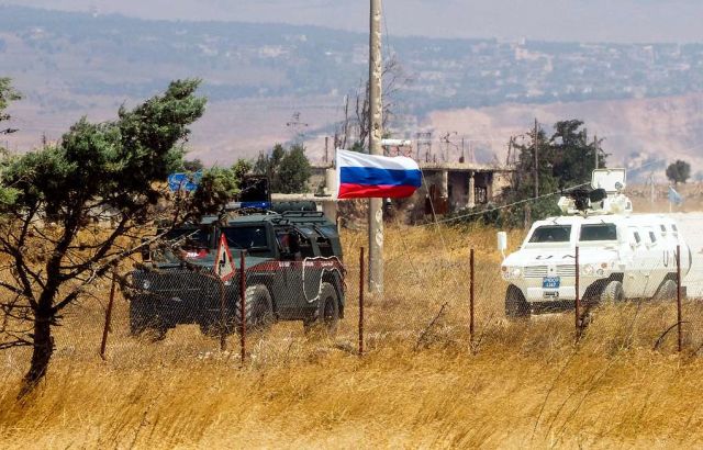 Автомобиль российской военной полиции обеспечивает проход колонны ООН к подножию Голанских высот через территорию Сирии, август 2018 года