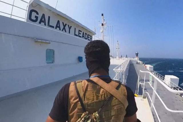 Боец-хусит стоит на грузовом корабле Galaxy Leader в Красном море