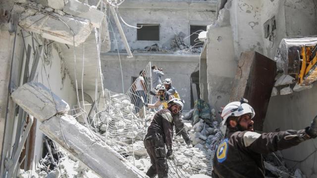 Члены "Сирийской гражданской обороны", также известные как "Белые каски" в руинах разрушенного здания