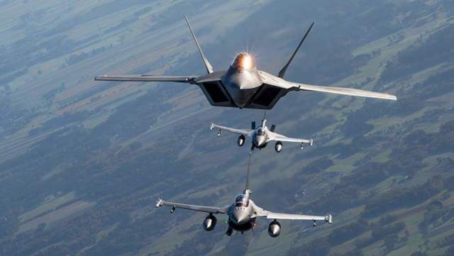 F-22 Raptor ВВС США летит вместе с двумя польскими F-16, авиабаза Ласк, Польша, 12 октября 2022 года