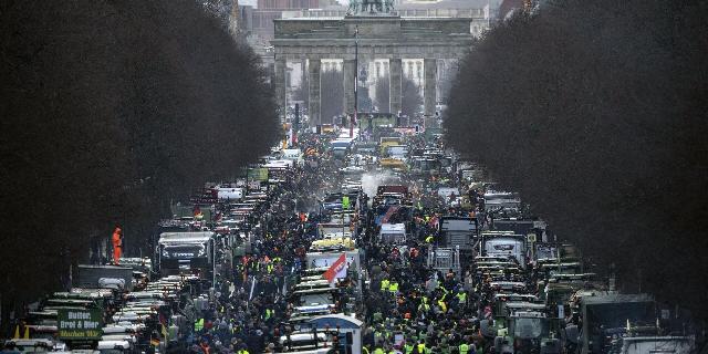 Фермеры с тракторами протестуют у Бранденбургских ворот в Берлине против плана отмены налоговых льгот на используемое ими дизельное топливо. 15 января 2024 года