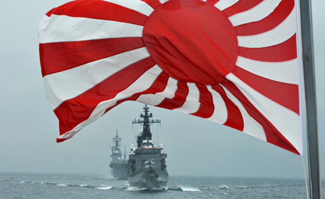 Флаг японских морских сил самообороны на фоне кораблей Kurama и Hyuga у залива Сагами
