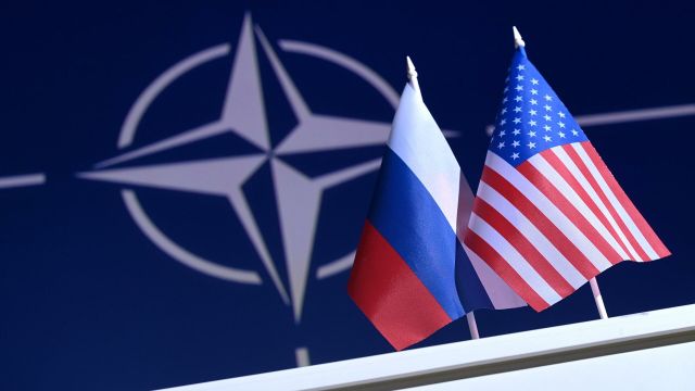 Флаги РФ и США на фоне логотипа НАТО