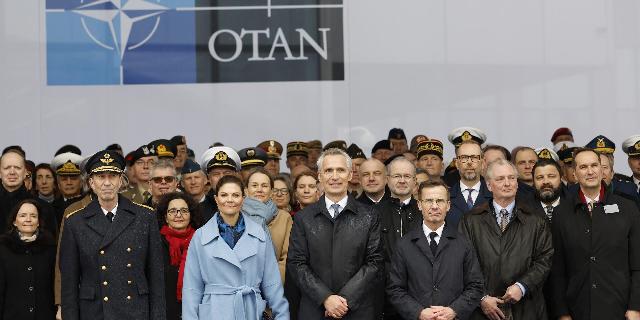 Генеральный секретарь НАТО Йенс Столтенберг, в центре, премьер-министр Швеции Ульф Кристерссон, справа от него, и наследная принцесса Швеции Виктория, слева от него, позируют с военными и штабным персоналом после церемонии по случаю вступления Швеции в НА