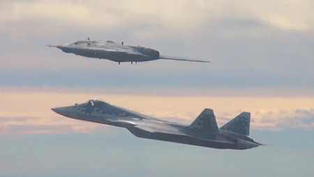 Истребитель пятого поколения Су-57 выполняет полет в паре с «верным ведомым» – беспилотником С-70. Кадр из видео министерства обороны РФ