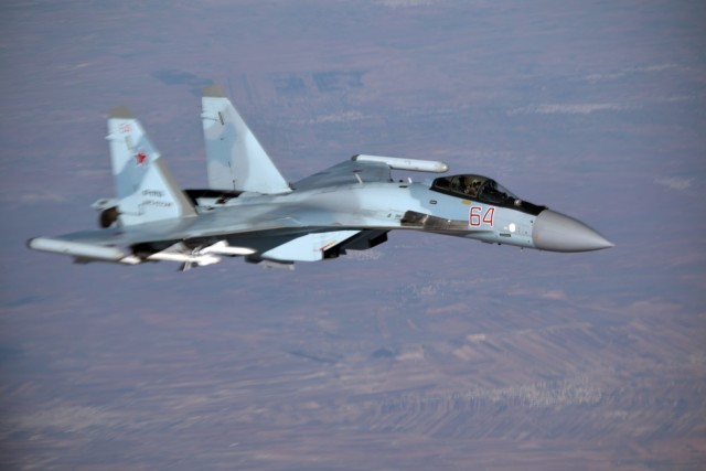 Истребитель Су-35С (бортовой номер "64 красный") из состава группировки ВКС России в Сирии сопровождает президентский самолет Ил-96-300ПУ(М1)