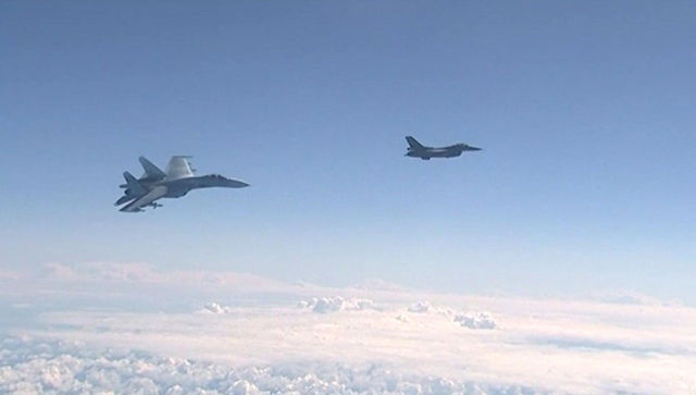 Истребитель НАТО F-16 и российский истребитель Су-27 над водами Балтики. Архивное фото