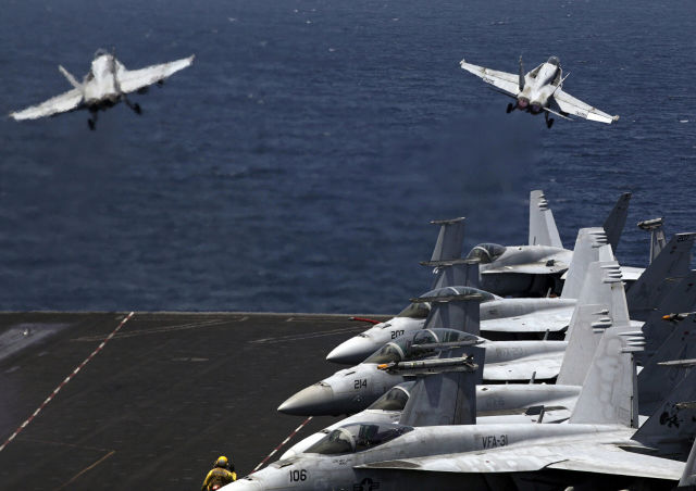 Истребители США F/A-18 вылетают с летной палубы авианосца США USS George H. W. Bush в Персидском заливе