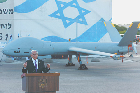 Израильский премьер Биньямин Нетаньяху выступает на базе ВВС Пальмахим. Фоном ему служит беспилотник Hermes-900. Фото Reuters