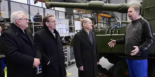 Канцлер Германии Олаф Шольц (в центре), министр обороны Борис Писториус (второй слева) в сопровождении генерального директора Rheinmetall Армина Паппергера (слева) беседуют с сотрудником на будущей площадке оружейного завода, где Rheinmetall планирует про