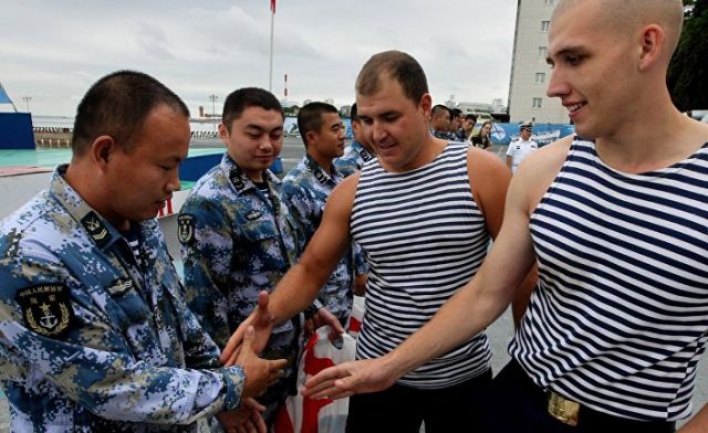 Китайские и российские моряки обмениваются рукопожатиями