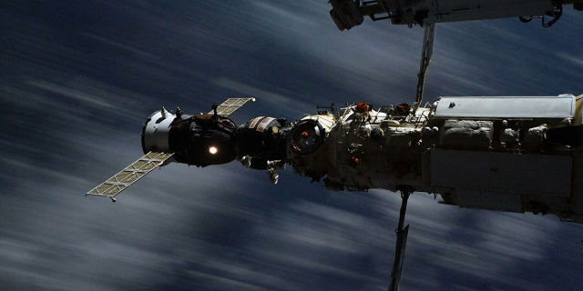 Космический корабль Союз стыкуется с МКС. Кадр снят на длинной выдержке, поэтому облака внизу размыты – скорость корабля 27 600 км/ч.