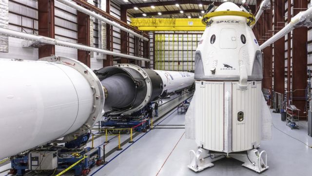 Космический корабль SpaceX Crew Dragon и ракета Falcon 9 в ангаре во время подготовки к испытательному полету