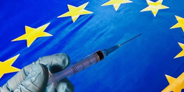 Медицинский шприц на фоне флага ЕС
