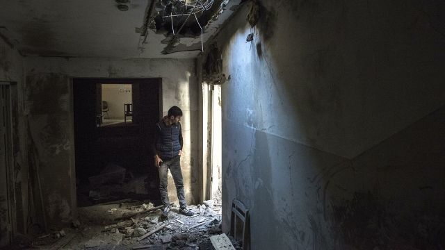 Местный житель в разрушенном доме в городе Шуши
