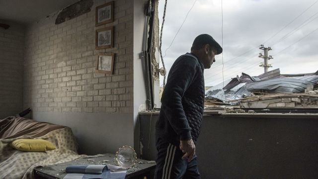 Местный житель в разрушенном доме в городе Степанакерт, который подвергся обстрелу