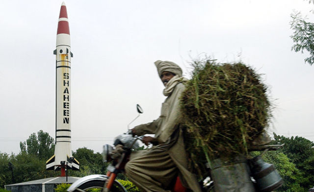 Местный житель проезжает мимо пакистанской баллистической ракеты "Шахин" в Исламабаде