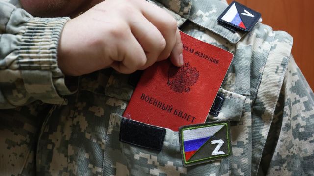 Мужчина, призванный на воинскую службу в ходе частичной мобилизации, кладет в карман военный билет