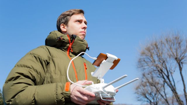 Мужчина управляет беспилотным летательным аппаратом