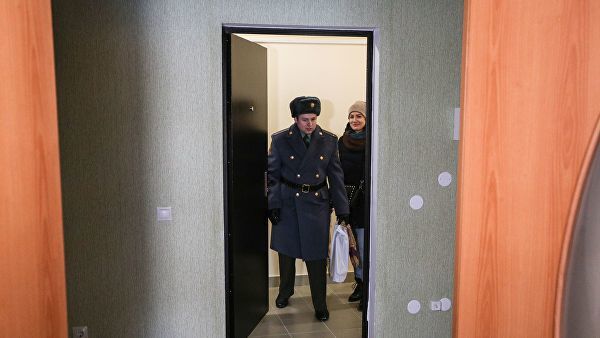 Новоселы заходят в свою новую квартиру после церемонии торжественной передачи служебного жилья военнослужащим войсковой части