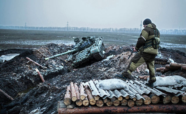 Ополченец стоит у танка украинской армии в Донецкой области