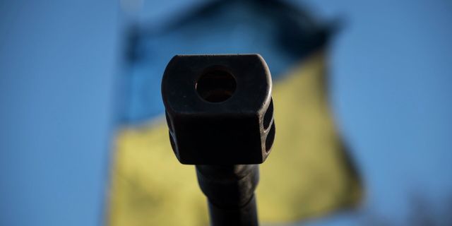 Оружейный ствол на фоне флага Украины