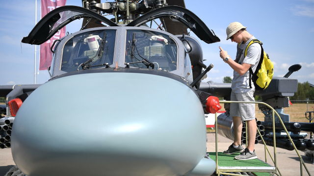 Посетитель фотографирует кабину российского разведывательно-ударного вертолета Ка-52 на Международном авиационно-космическом салоне МАКС-2021