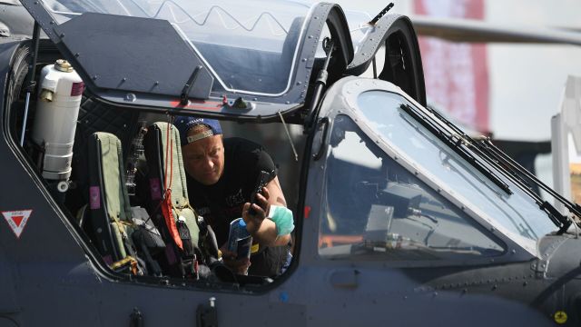 Посетитель фотографирует кабину российского разведывательно-ударного вертолёта Ка-52 на Международном авиационно-космическом салоне МАКС-2021