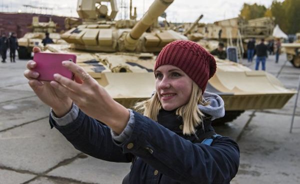Посетитель фотографируется на фоне танка Т-90А на 10-й международной выставке Russia Arms Expo