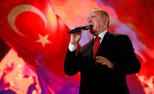 Прензидент Турции Реджеп Тайип Эрдоган на фоне турецких флагов