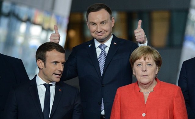 Президент Франции Эммануэль Макрон, президент Польши Анджей Дуда и федеральный канцлер ФРГ Ангела Меркель на церемонии фотографирования глав делегаций стран-участниц НАТО