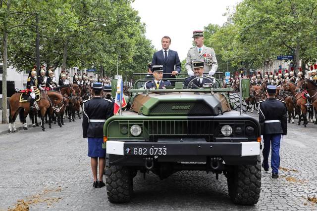 Президент Франции Эмманюэль Макрон и начальник Главного штаба Вооруженных сил Франции Франсуа Лекуантр на автомобиле VLRA во время парада в честь Дня взятия Бастилии, 14 июля 2019 года