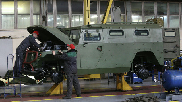 Рабочие осматривают бронеавтомобиль "Тигр" на машиностроительном заводе. Архивное фото