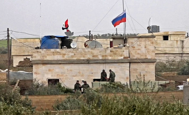 Российский флаг над зданием в районе Аримах к западу от Манбиджа недалеко от турецкой границы