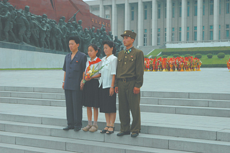 Северокорейский военнослужащий и члены его семьи у мемориала воинской славы в Пхеньяне. Фото Владимира Карнозова