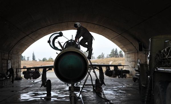 Сирийский летчик осматривает самолет МИГ-21 сирийских ВВС перед вылетом на авиабазе "Хама"