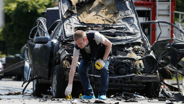 Следователи на месте взрыва машины в Киеве, 27 июня 2017 года