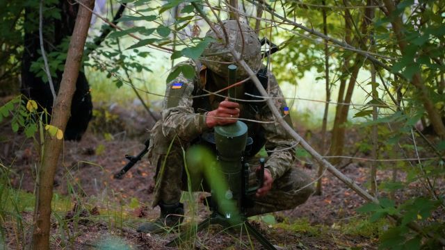 Солдат спецподразделения Украины устанавливает немецкую противотанковую мину направленного действия DM22 в Донецкой области