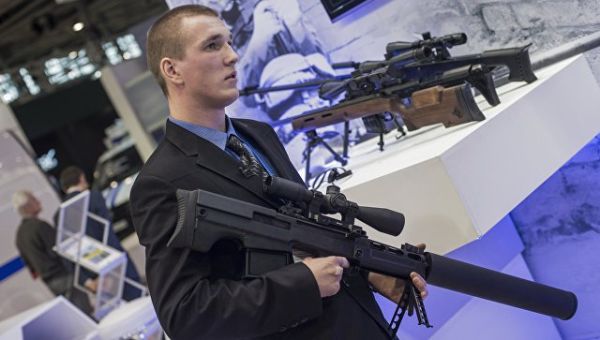 Сотрудник со снайперской крупнокалиберной бесшумной винтовкой Выхлоп на стенде компании Ростех. Архивное фото