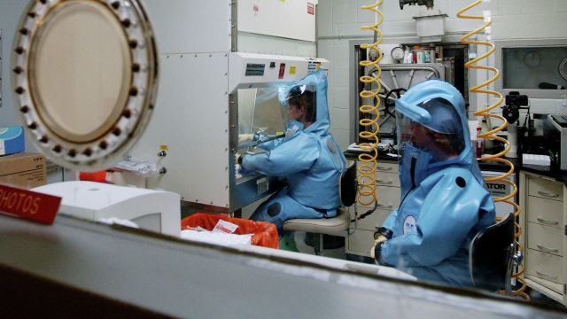 Сотрудники лаборатории Медицинского исследовательского института инфекционных заболеваний армии США в Форт-Детрике в костюмах биологической защиты