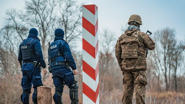 Сотрудники полиции Польши и польский военнослужащий на границе с Белоруссией