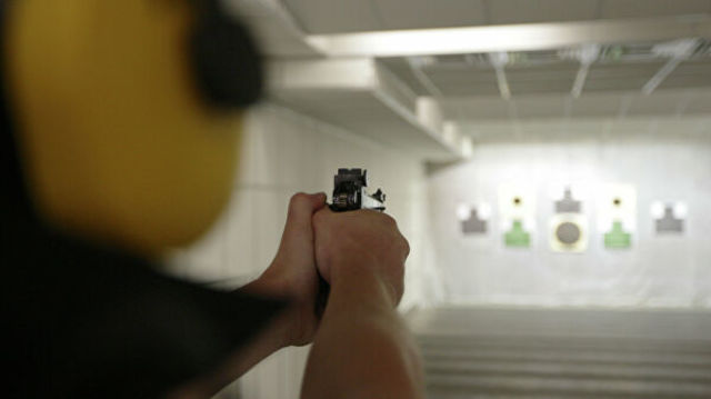 Спортсмен стреляет по мишеням из пистолета