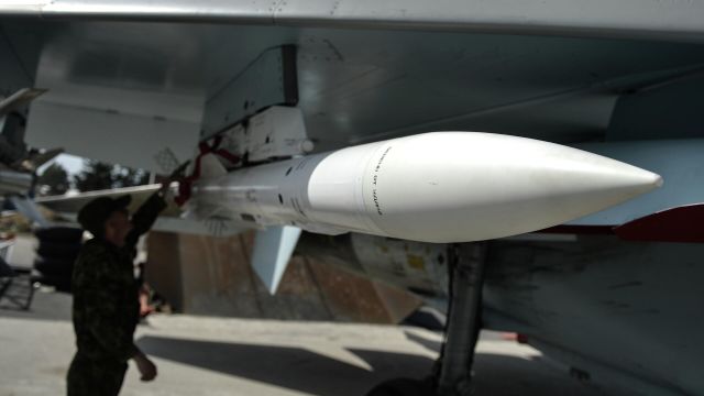 Техник проверет ракету на самолете