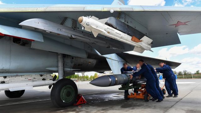 Техники подвозят авиационную ракету, чтобы смонтировать на истребитель ВКС России, задействованный в специальной военной операции на Украине