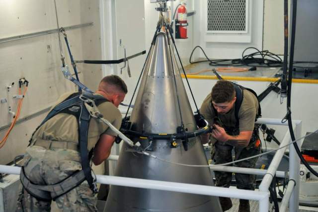 Техники ВВС США закрепляют титановый кожух на верхней части межконтинентальной баллистической ракеты Minuteman III