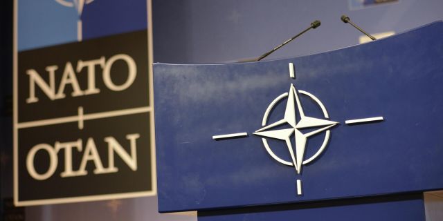 Трибуна в зале для пресс-конференций штаб-квартиры НАТО.