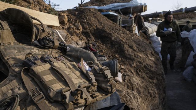 Укомплектованный бронежилет военнослужащего армии Украины лежит на краю окопа