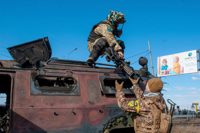 Украинские солдаты осматривают поврежденную военную технику в Харькове, 27 февраля 2022 года