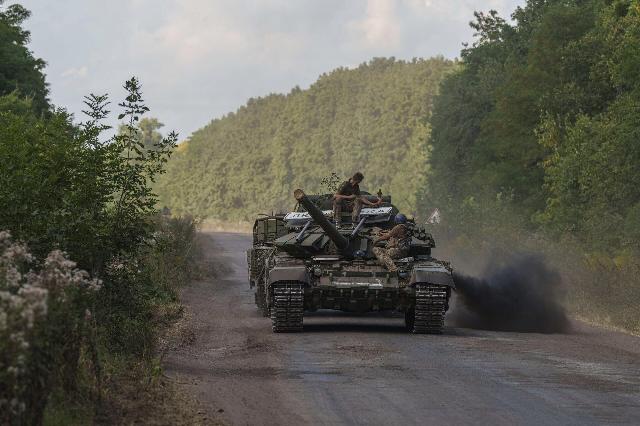 Украинские военнослужащие едут на танке с табличкой "Любимовка" недалеко от российско-украинской границы в Сумской области